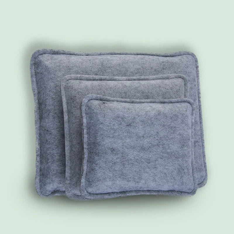 A stack of gray needle felting mats for wool crafting.