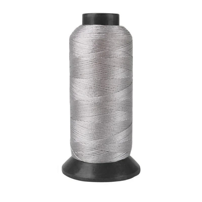 A spool of gray heavy-duty nylon sewing thread for upholstery and denim.