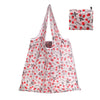 A white reusable shopping tote bag featuring a pattern of red strawberries and green leaves.