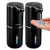 A black touchless automatic soap dispenser with a pump mechanism is shown next to a hand.