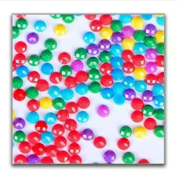 Assortiment coloré de petites perles en plastique rondes dans diverses nuances de vert, rouge, jaune et violet.