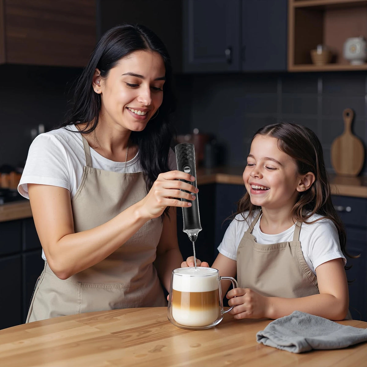 A woman is using a rechargeable handheld milk frother to froth milk in a glass for a child.