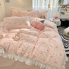 A pink and white checkered duvet cover set featuring floral charm with a ruffled edge and three pillows.