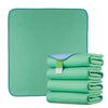 A stack of green reusable waterproof underpads placed on a teal green mat.