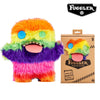 An orange, green, and purple fluffy monster plush toy with a pink tongue and large eyes.