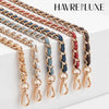 Multiple strands of braided metal chains in gold, copper, and blue are displayed on a white surface.