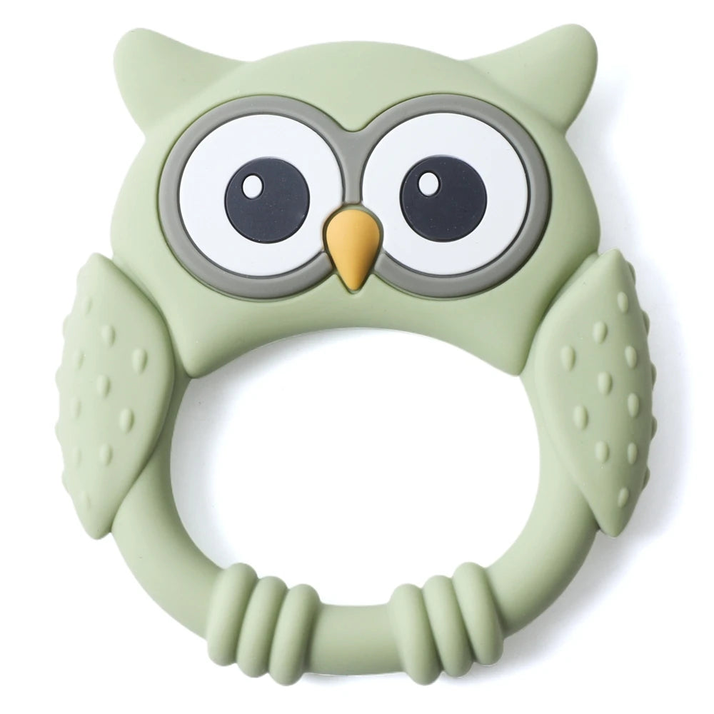 A light green silicone owl-shaped teether and rattle for babies with large eyes and textured body.