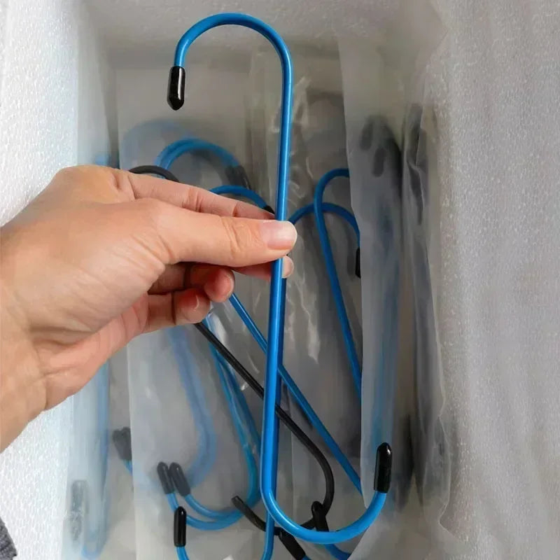 Une main tient un outil de pince pour étrier de frein automobile bleu dans un contenant en plastique transparent.