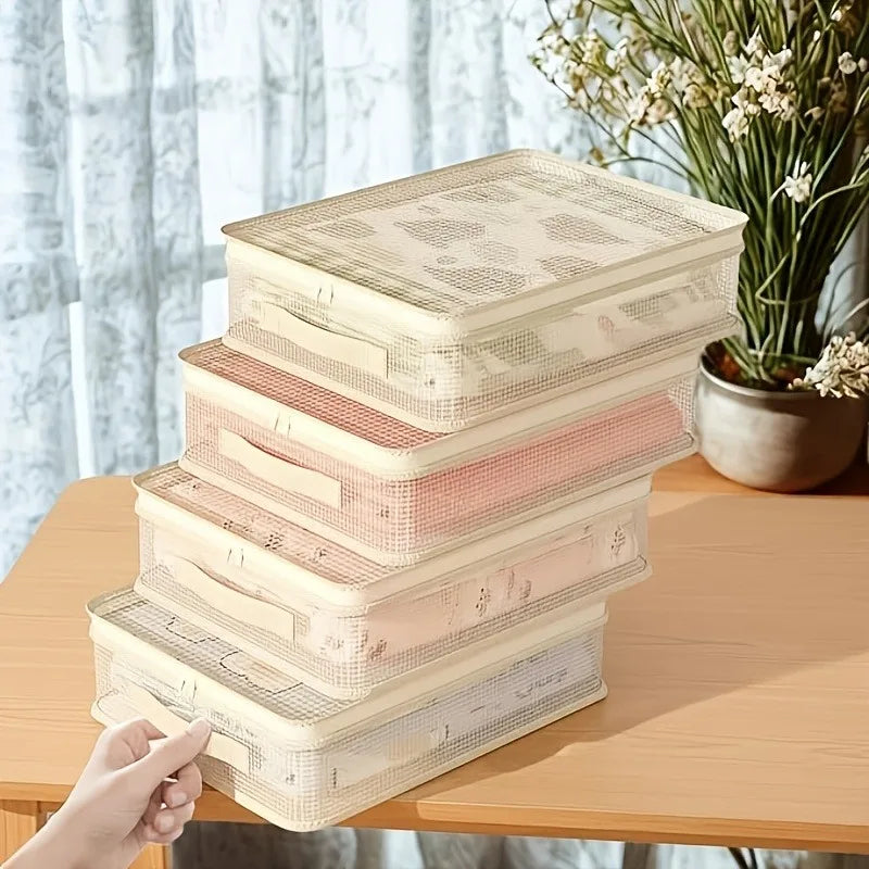 A stack of foldable bedding storage bags in light beige and pink tones resting on a wooden table.