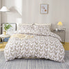 A bed with a heart print duvet cover set in soft blue and gray tones, featuring pillows and bedside lamps.