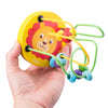 A hand holds a wooden bead maze roller coaster toy featuring a lion design and colorful beads.