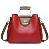 A red leather vintage crossbody tote bag with brown trim and a leather handle.