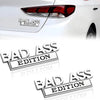 Nahaufnahme einer roten Heckleuchte eines weißen Autos mit einem Aufkleber der Bad Ass Edition.