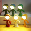 A set of bendable robot night lights in various colors, including black, blue, green, red, white, and yellow, illuminated on 