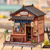A detailed miniature Japanese book nook kit featuring a traditional wooden shop facade with lighting elements.