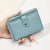 A hand holds a light blue slim PU leather card holder wallet with a gold zipper and silver-toned button.