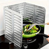 Foldable aluminum stove splatter guard with a green pan on a black stovetop.