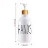 White bottle with a wooden pump dispenser for hand soap and dish soap.