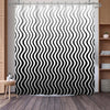 Black and white wavy stripe shower curtain hanging in a bathroom setting
