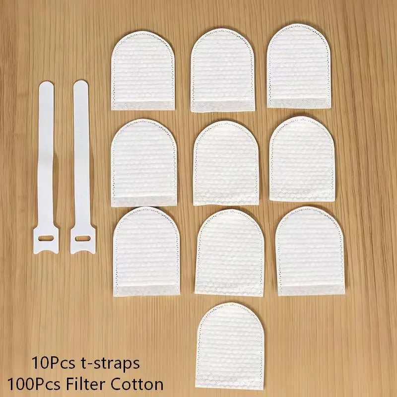 A collection of ten white t-straps or filter bags made of cotton are arranged on a wooden surface.