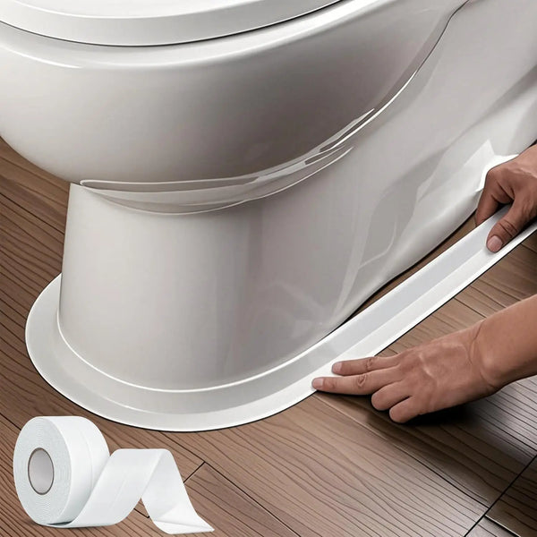 A hand applies white silicone caulk tape to the base of a white ceramic toilet bowl.