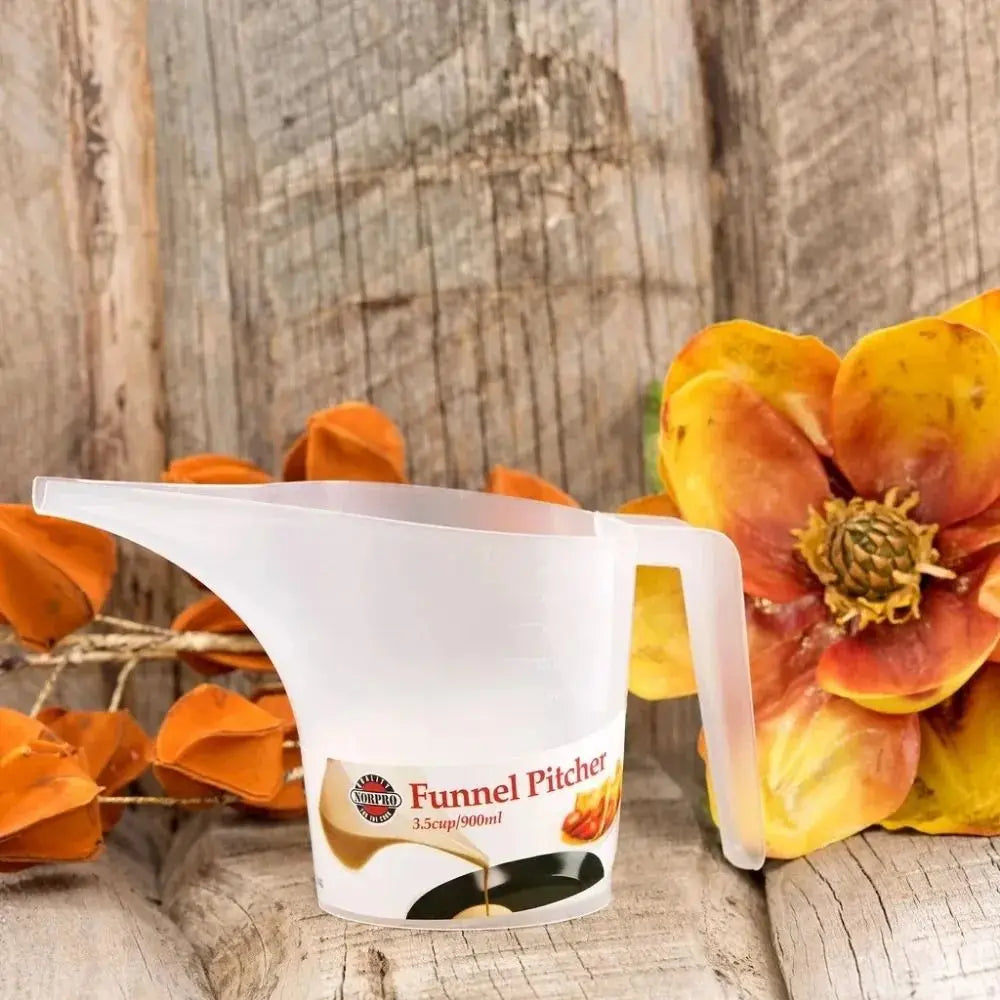 A white plastic funnel pitcher is shown next to orange and yellow rose petals on a wooden surface.