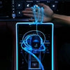 A hand is connecting a blue LED light strip to a device screen inside a car interior.