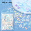A clear plastic container filled with iridescent holographic star sequins scattered on a blue surface.