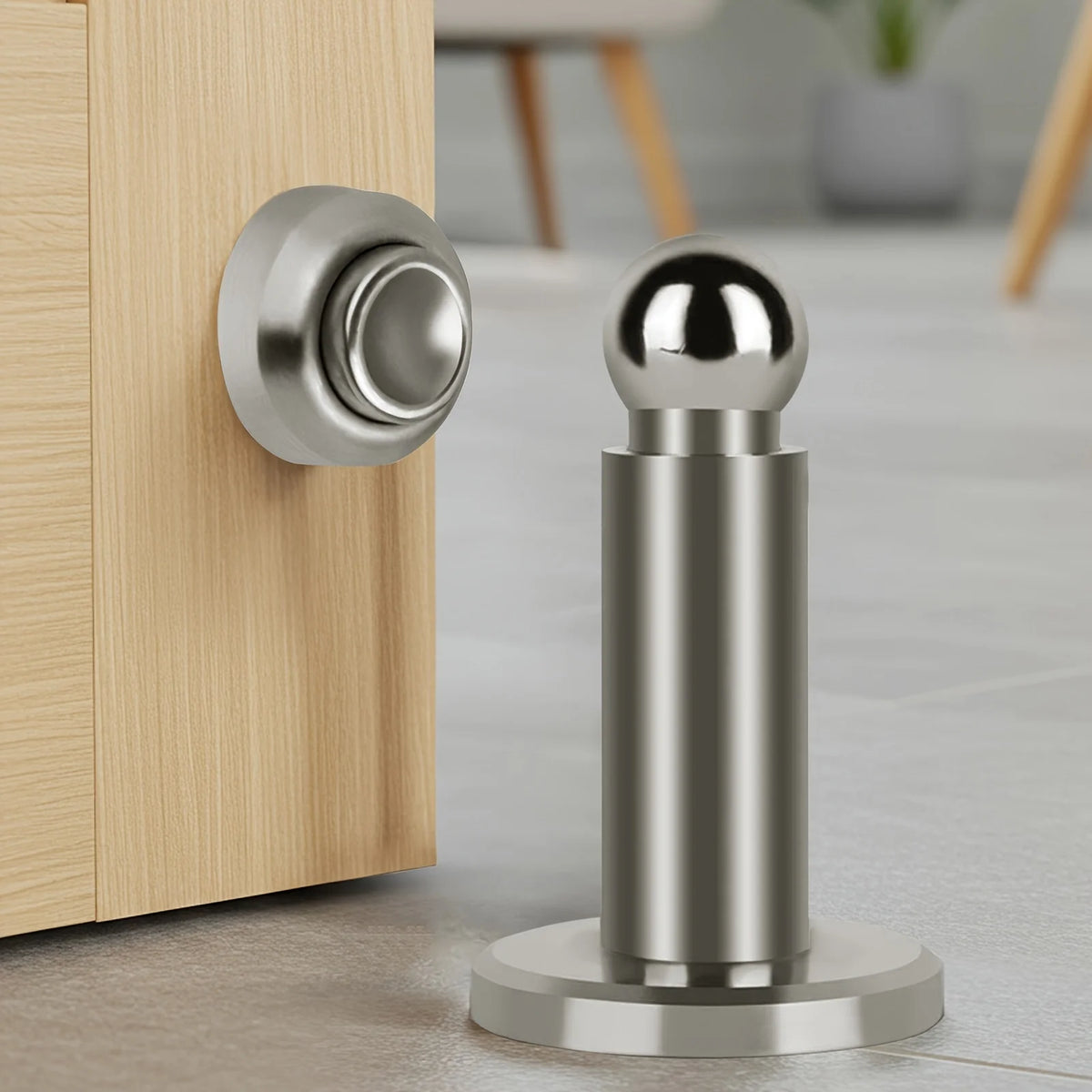 Silberner magnetischer Türstopper mit sphärischem Kopf und zylindrischem Körper, montiert auf einem Holzrahmen.