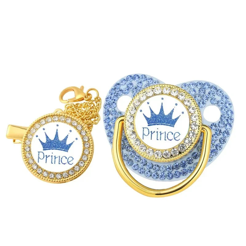 A set of crystal rhinestone pacifier chain clips with silicone nipples in gold and blue.