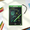 A green portable LCD drawing tablet is shown on a white desk with colored pencils nearby.