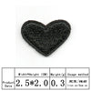 A black heart shaped iron-on patch with embroidered texture.