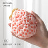 A hand is holding a pink bath ball cheese product, which is a soft mesh sponge for baby.