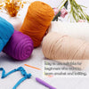 A collection of thick orange, purple, and beige yarn skeins with crochet hooks and needles for beginners.