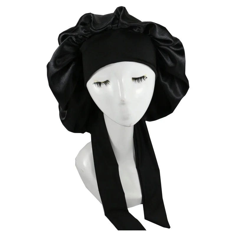 Black satin sleep cap with ruffled edges displayed on a mannequin head.