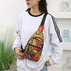 A woman wearing a white sweatshirt holds a colorful leaf print sling crossbody bag with multiple pockets.