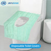 A disposable toilet cover in light green tissue paper placed on a white toilet seat.