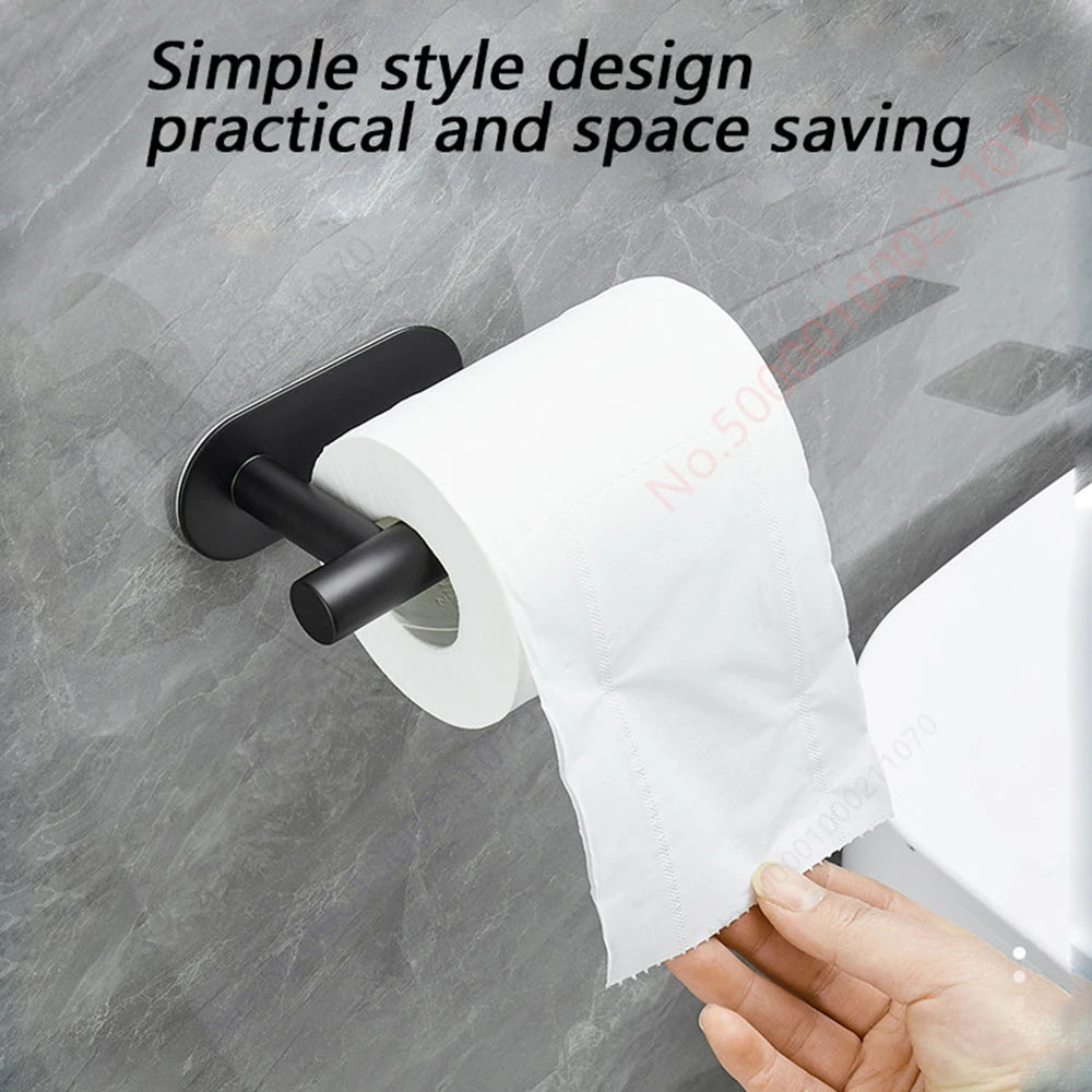 A hand is pulling a roll of white toilet paper from an adhesive stainless steel toilet paper rack.