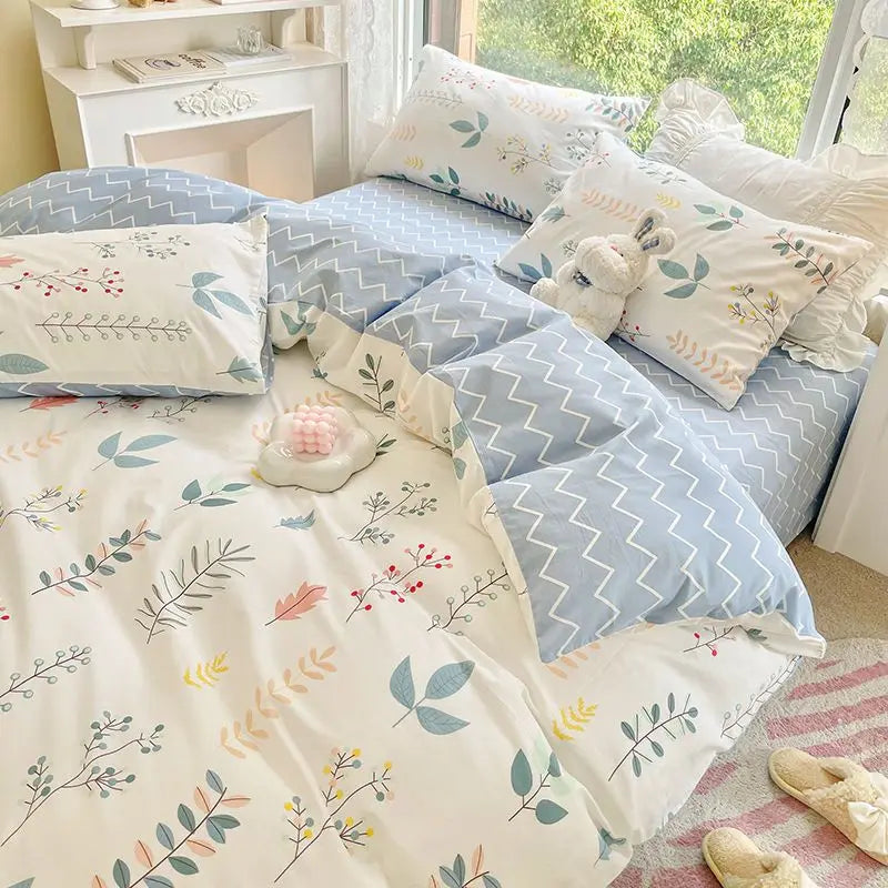 Pink floral bedding set featuring a duvet cover and pillows with white and blue patterns.