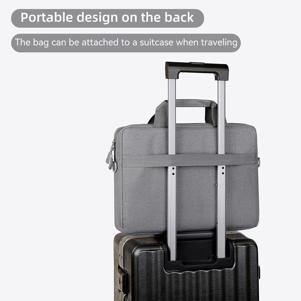 A gray portable laptop bag with a handle is shown attached to a black suitcase.