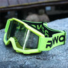 Lime green and black retro motorcycle sunglasses with night vision lenses resting on a gray rock.