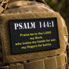A tan military patch embroidered with Psalm 144:1 in gold thread on a canvas fabric.