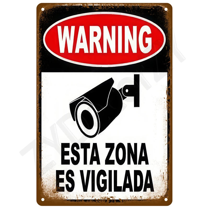A vintage metal tin sign with a red warning oval and black text indicating a monitored zone.