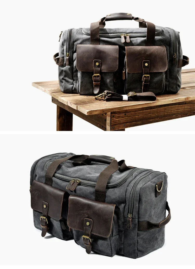 A dark gray canvas duffel bag with brown leather pockets resting on a wooden surface.