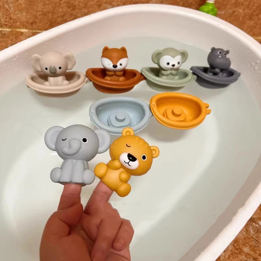 A hand is dipping silicone animal finger puppets into a white bowl of water for toddlers.