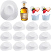 A set of miniature cowboy hats for party favors and cake toppers displayed next to a glass bottle.