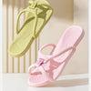 A pair of light green foldable EVA travel slippers for home and hotel, shown in a natural light setting.