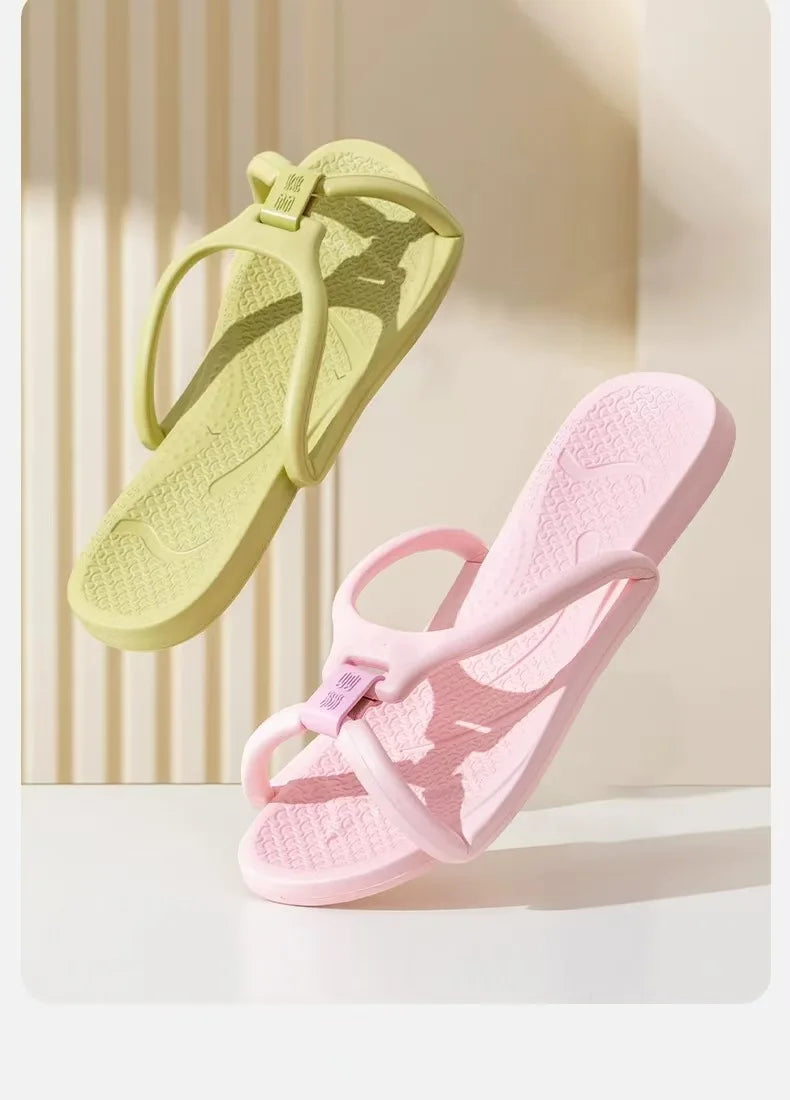 A pair of light green foldable EVA travel slippers for home and hotel, shown in a natural light setting.