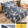 Une jupe de lit bleu foncé imprimée avec des motifs floraux blancs, montrant son bord froncé.