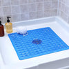A blue non-slip shower mat with suction cups is placed inside a white bathtub.